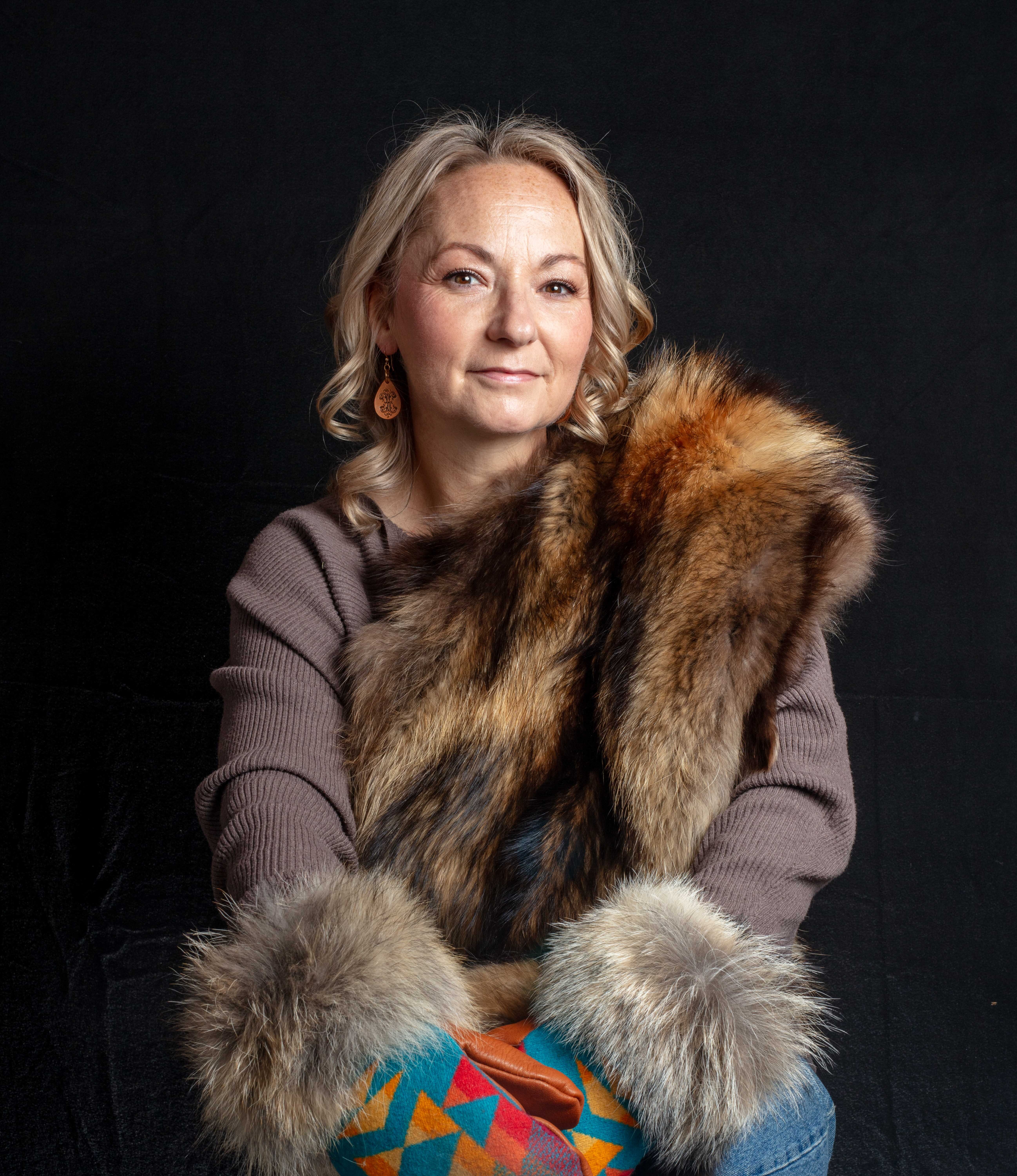Barb Genert displaying fabric and fur mittens