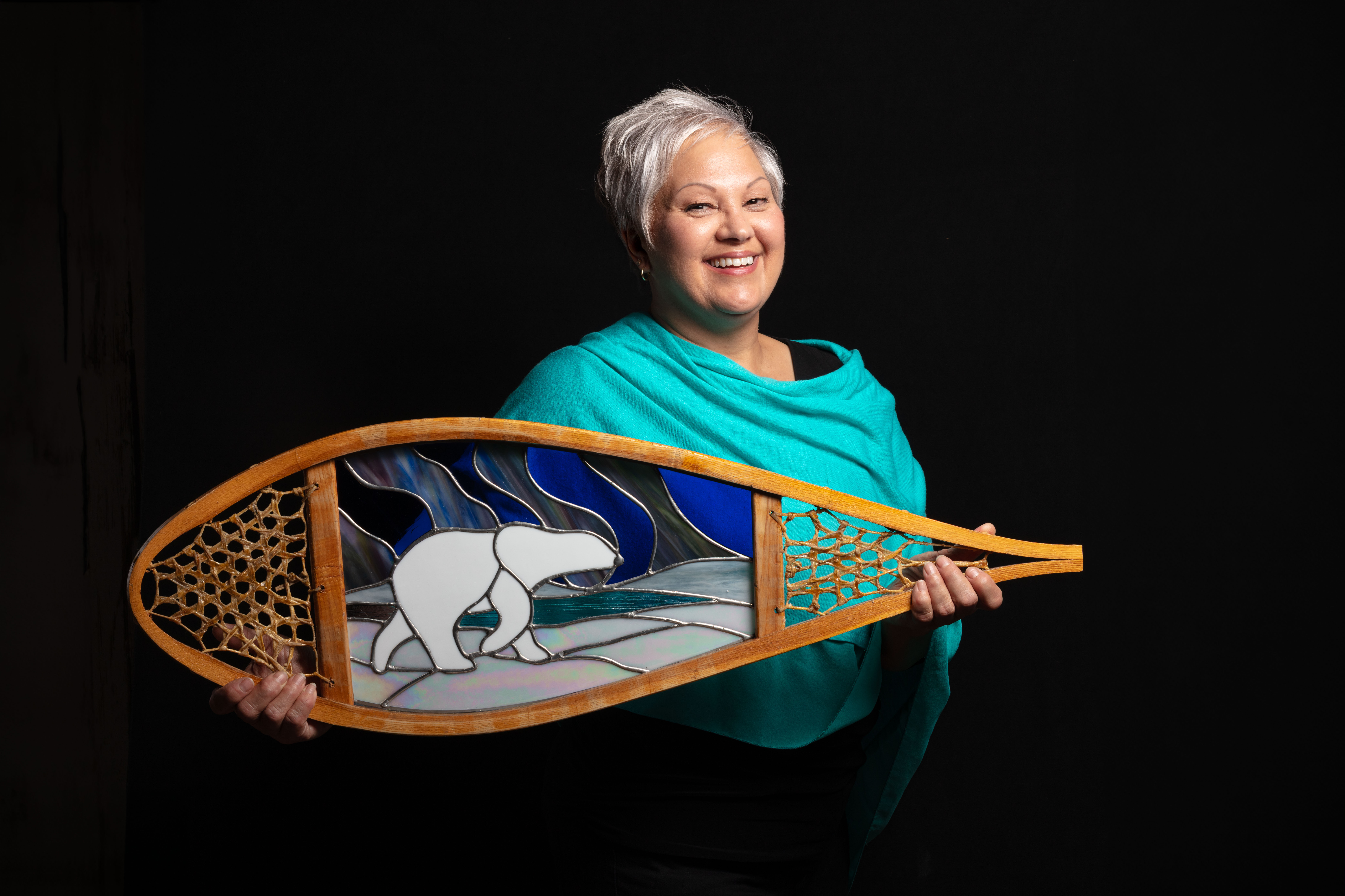 Marlys Phillips holding a stained glass window