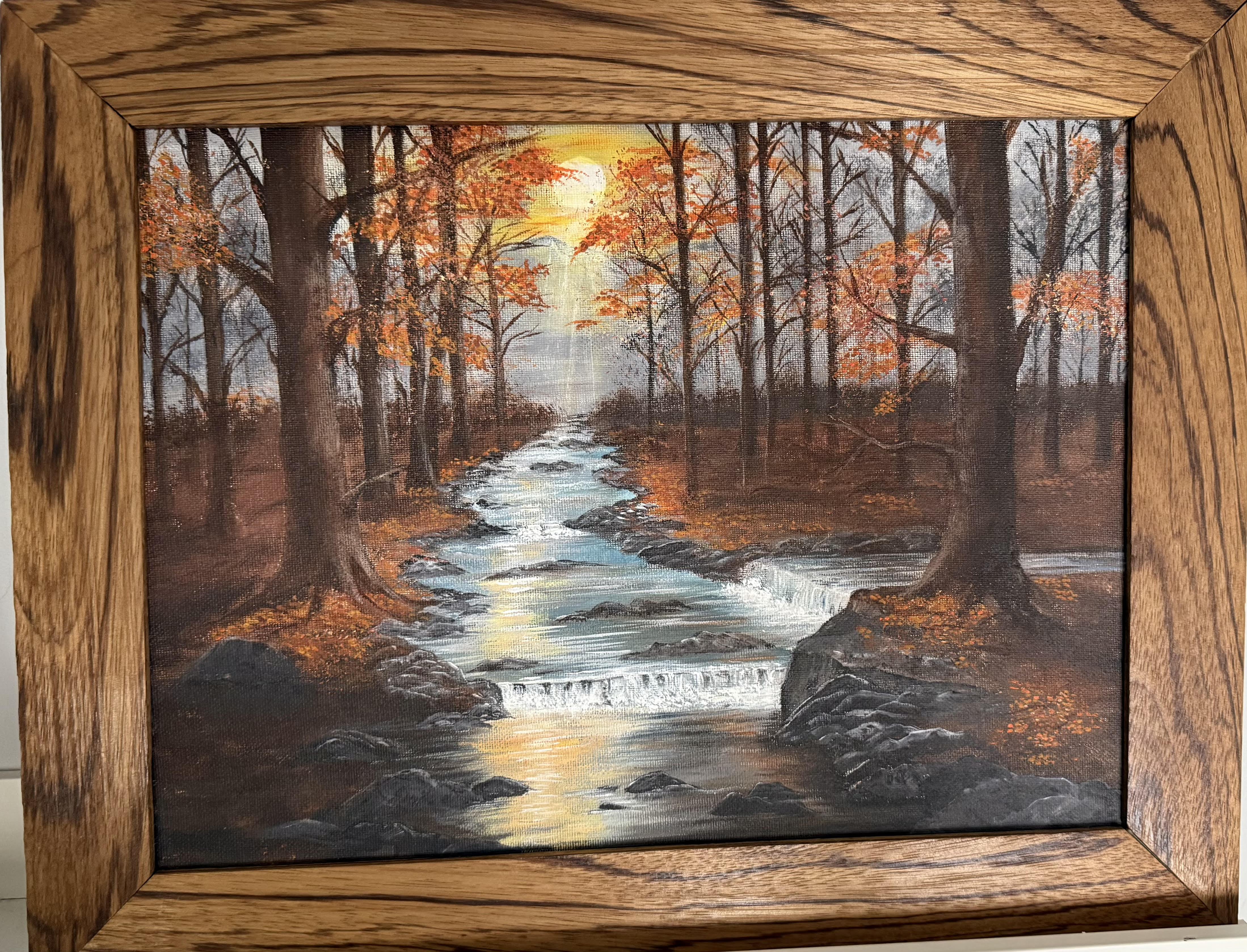 Susan Thompson standing with her landscape paintings